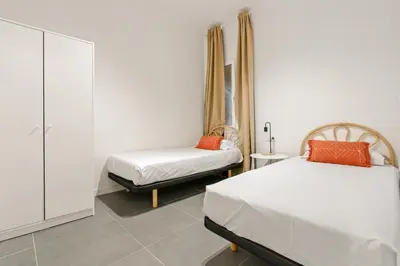 a bedroom with two beds and a cabinet at Flateli Espronceda 11 in Barcelona
