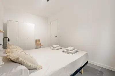 a white bedroom with a bed with white cabinets at Flateli Espronceda 22 in Barcelona