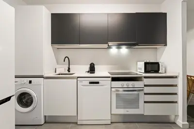 a white kitchen with a stove and a microwave at Flateli Espronceda 22 in Barcelona