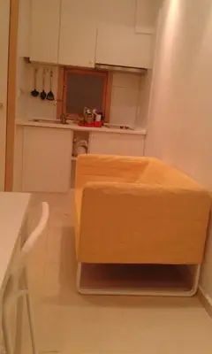a kitchen with a wooden stool in the middle of a room at 016 DUPLEX centric in Barcelona