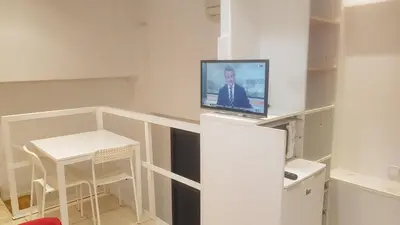 a room with a tv on a shelf with a table at 016 DUPLEX centric in Barcelona