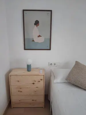 a bedroom with a bed and a dresser with a picture on the wall at Casa Vella de Casa Torrent in Canet de Mar