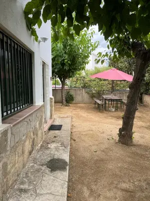 a pink umbrella and a table and a tree at Casa Vella de Casa Torrent in Canet de Mar