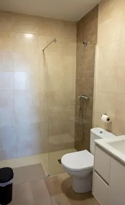 a bathroom with a toilet and a glass shower at Casa Vella de Casa Torrent in Canet de Mar