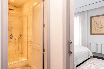 a bathroom with a walk in shower next to a bedroom at Paseo de Gracia Icon Apartment in Barcelona
