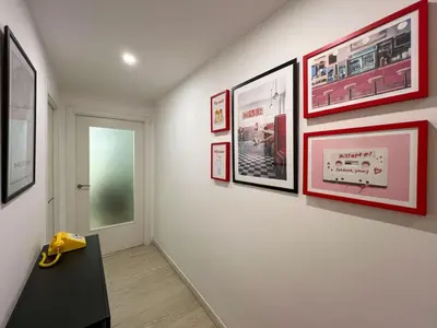 a hallway with pictures on a wall and a door at Stay U-nique Apartment Roma in Barcelona