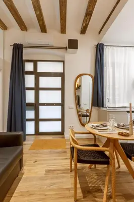 a living room with a table and a mirror at Lodging Apartments Almirall Beach B1 in Barcelona