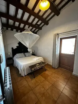 a bedroom with a white bed and a window at Maset del Garraf in Olesa de Bonesvalls
