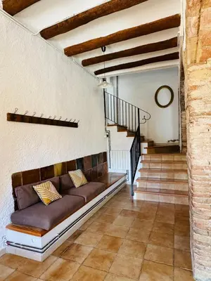 a living room with a couch and a staircase at Maset del Garraf in Olesa de Bonesvalls