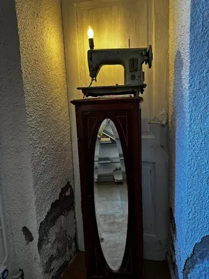 a mirror next to a door with a sewing machine at Maset del Garraf in Olesa de Bonesvalls