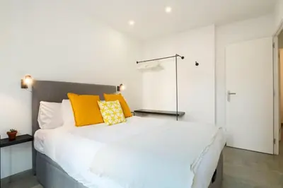 a bedroom with a large white bed with yellow pillows at Stay U-nique Tapioles Central Apartment in Barcelona