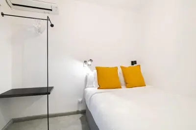 a bedroom with a bed with yellow pillows on it at Stay U-nique Tapioles Central Apartment in Barcelona