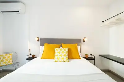 a bedroom with a bed with yellow pillows at Stay U-nique Tapioles Central Apartment in Barcelona