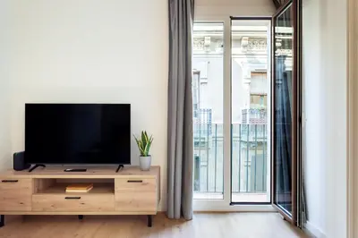 a living room with a flat screen tv on a wooden cabinet at Art House Travessera de Gràcia-2 in Barcelona