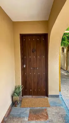 a large wooden door with a plant in front of it at Can Davilas Rustic Mountain House in Monistrol de Calders