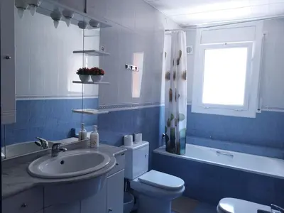 a blue bathroom with a sink and a toilet at La Casa de Vacaciones in Terrassa