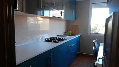 a kitchen with blue cabinets and a white counter top at La Casa de Vacaciones in Terrassa
