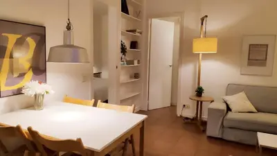 a table with a vase of flowers and a figurine on it at Rambla-Plça Catalunya 2BR monthly stays -R.H in Barcelona