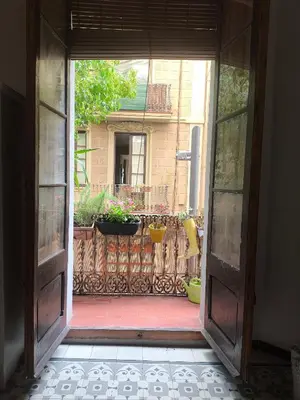 an open door to a yard with potted plants at Habitación grande con balcón y mucha luz in Barcelona
