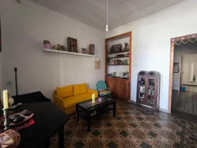 a living room with a yellow couch and a table at Habitación grande con balcón y mucha luz in Barcelona