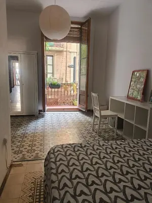 a bedroom with a bed and a desk and a chair at Habitación grande con balcón y mucha luz in Barcelona