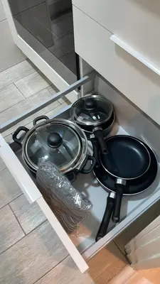 two pans and a strainer in a kitchen drawer at Apartamento cerca de Camp Nou in Hospitalet de Llobregat