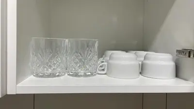 a white shelf with a vase and cups on it at Apartamento cerca de Camp Nou in Hospitalet de Llobregat