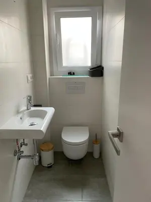 a bathroom with a toilet and a sink and a window at Apartamento cerca de Camp Nou in Hospitalet de Llobregat