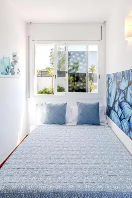 a bedroom with a large bed with blue pillows at Yasmine Casas Barcelona in Olivella