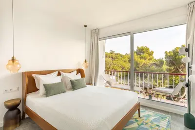 a bedroom with a bed and a large window at SeaSunSand Apartment in San Pol de Mar