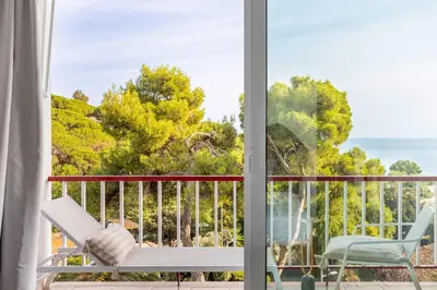 a room with a balcony with a view of the ocean at SeaSunSand Apartment in San Pol de Mar