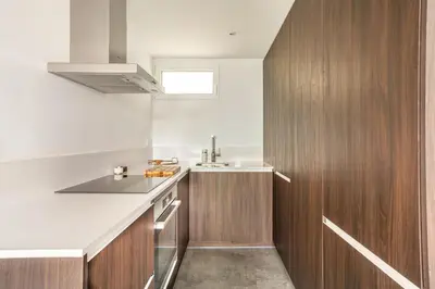 a kitchen with wooden cabinets and a sink at SeaSunSand Apartment in San Pol de Mar