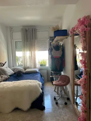 a bedroom with a bed and a chair and a window at Habitacion in Esparreguera