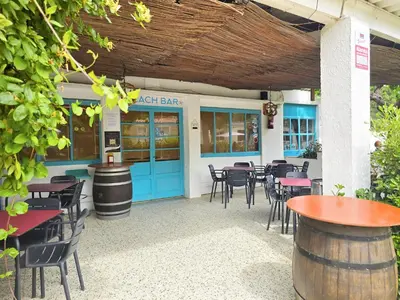 a restaurant with blue doors and tables and chairs at Bungalow in Canet de Mar near Scenic Beach in Canet de Mar