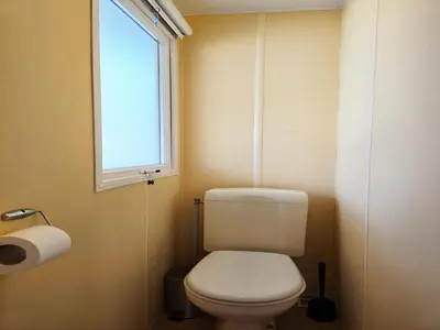 a small bathroom with a toilet and a window at Bungalow in Canet de Mar near Scenic Beach in Canet de Mar