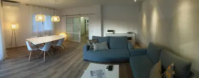 a living room with a blue couch and a table at Rustic good in Sitges