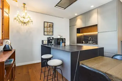 a kitchen with a bar with stools and a table at Cozy Apartment in Barcelona in Barcelona