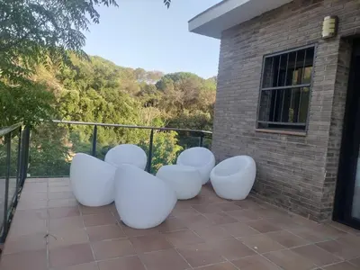 a group of white chairs sitting on a balcony at Large house surrounded by nature in Vilanova de la Roca