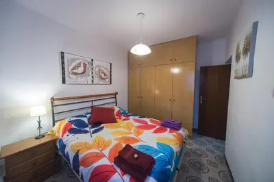 a bedroom with a bed with a colorful blanket at Comodo y luminoso en Cornella -Barcelona- in Cornellà de Llobregat