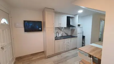 a kitchen with white cabinets and a sink and a table at Vallgorguina Uno in Vallgorguina