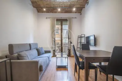 a white bed in a room with a window at Apartamento familiar en Barcelona in Barcelona