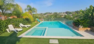 a swimming pool with two chairs and a slide at The Family Palace in Piera
