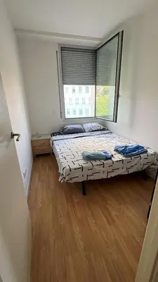 a bedroom with two beds and a large window at Habitación mediana in Santa Coloma