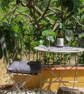 a table with a bottle of wine and two glasses at Refugio verde con encanto in Vallirana