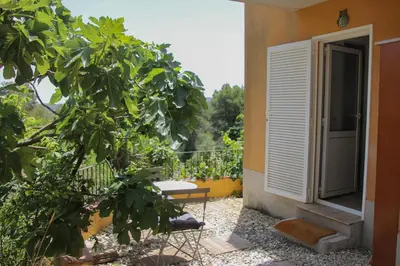 an open door to a balcony with a bench and trees at Refugio verde con encanto in Vallirana