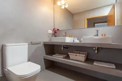 a bathroom with two sinks and a toilet and a mirror at Lodging Apartments Beach Apartment Villa Olimpica in Barcelona