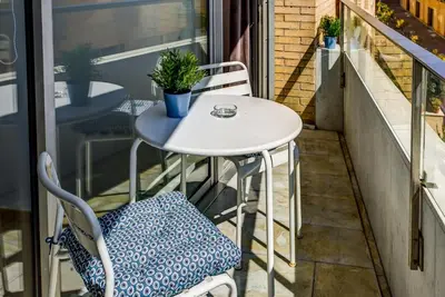 a small white table and chairs on a balcony at Lodging Apartments Beach Apartment Villa Olimpica in Barcelona