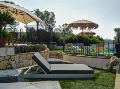 a patio with a chair and an umbrella at Mikasi Hills by Hello Homes Sitges in Sant Pere de Ribes