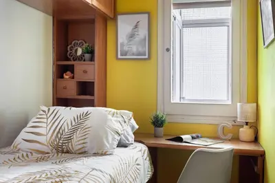 a bedroom with a bed and a desk and a window at Apartamento Moderno con Balcón Meridiana Barcelona in Barcelona