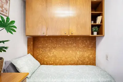 a bedroom with a bed and a wooden cabinet at Apartamento Moderno con Balcón Meridiana Barcelona in Barcelona